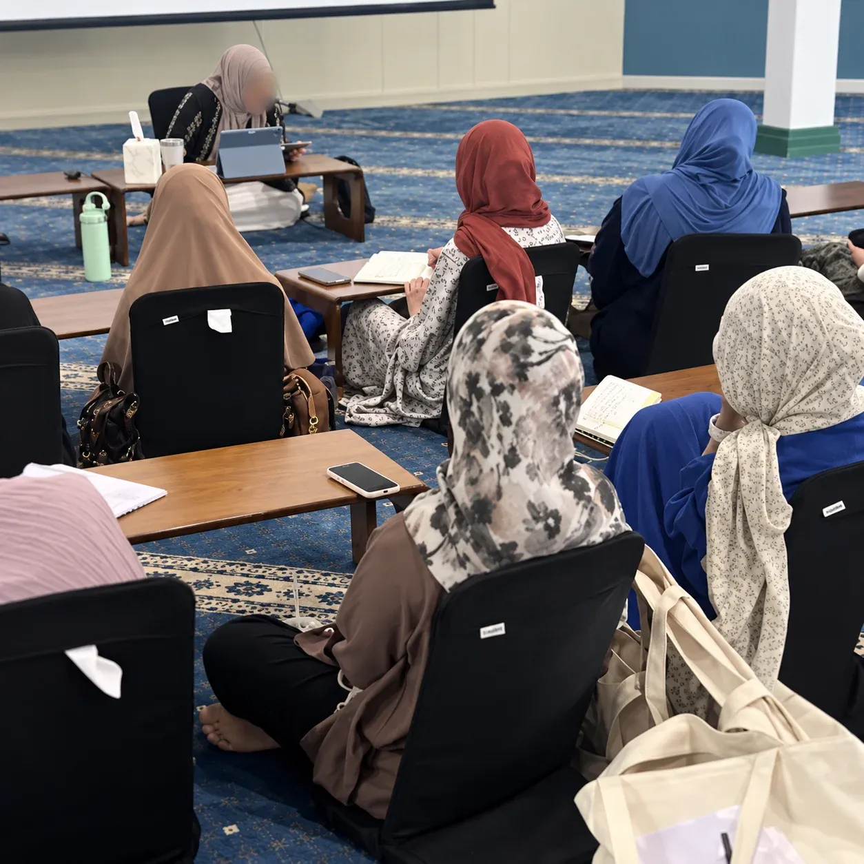 Women in a Sabeel class, seated on the floor before their teacher