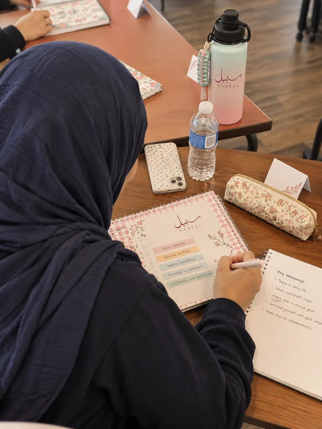 A Sabeel student taking notes in class
