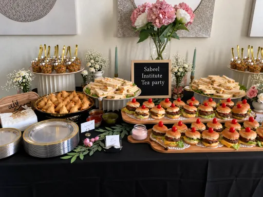 A Sabeel tea party table with sandwiches, samosas, and sliders
